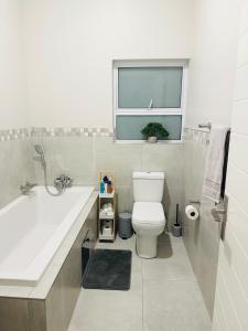 比勒陀利亚Shamah的一间带水槽和卫生间的浴室以及窗户。
