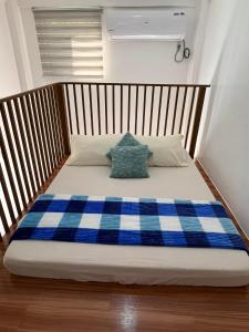 MangataremArzel's Tiny House的一张带蓝色和白色铺面毯子的床