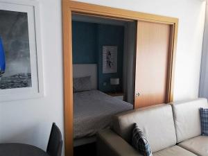 纳扎雷Apartamentos Turisticos da Nazare的镜子反射着一间卧室,卧室配有一张床和一张沙发