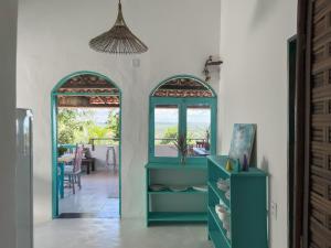 阿拉亚尔达茹达Vila Rita Hostel Arraial d'Ajuda的客房设有2扇拱形窗户和蓝色橱柜。