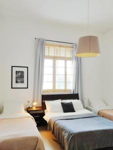 海法伊甸园酒店的一间卧室设有两张床和窗户。