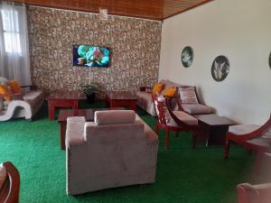 基苏木VICTORIA RIPPLE HOTEL { WINAM }的带沙发和绿色地毯的客厅