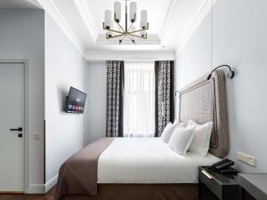 圣彼得堡Helvetia Hotel的一间卧室配有一张大床和一个吊灯。