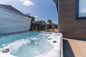 罗伊登Roydon Marina - Lodge 1 - Hot Tub的房屋甲板上的热水浴池