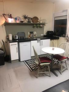 戈尔韦Bob’s Cabin的厨房配有桌子、两把椅子和一张桌子