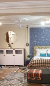 KoforiduaNana Adu Guest House的一间卧室设有一张床和蓝色的墙壁