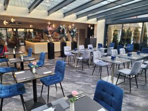 腓特烈港Villa Natalia am See的一间配备有桌子和蓝色椅子的用餐室