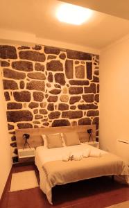 塞亚Recanto da Neta的一间卧室设有石墙和床