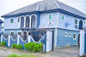 UghelliMena's Home & Apartment的前面有栅栏的蓝色房子