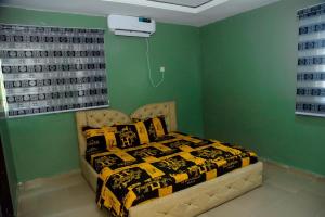UghelliMena's Home & Apartment的一间设有床铺的卧室,位于一个拥有绿色墙壁的房间