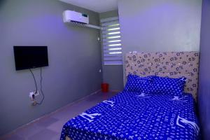 UghelliMena's Home & Apartment的一间卧室配有一张带蓝色棉被的床