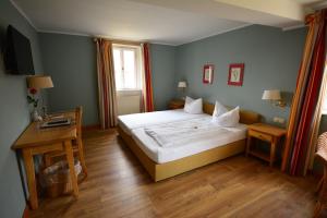 布滕汉姆施洛斯布滕汉姆兰德酒店的卧室配有一张白色的大床和一张桌子