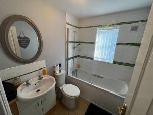 西部德比Modern 3 Bedroom House Close to Liverpool Centre的浴室配有盥洗盆、浴缸、卫生间和盥洗盆。