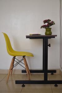 内罗毕Juliett Wonder Furnished Apartment的坐在桌子旁的黄色椅子上,植物