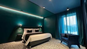诺拉NOLA BOUTIQUE HOTEL - self check-的绿色卧室配有床和椅子
