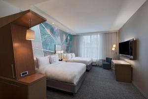 麦迪逊Courtyard by Marriott Jackson Madison的酒店客房设有两张床和一台平面电视。