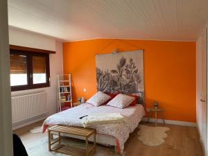 IdronChambre Sayulita/Spa/piscine的一间卧室配有一张橙色墙壁的床