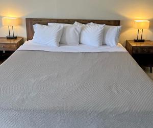 霍玛Red Carpet Inn - Houma的一张白色大床,配有白色枕头和两盏灯