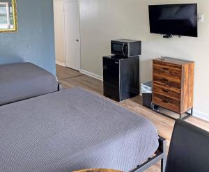 霍玛Red Carpet Inn - Houma的客房设有一张床和一台平面电视。