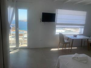 阿基奥斯·索斯蒂斯·米科诺斯Agean Studio with Breathtaking Views的白色的客房设有一张桌子,享有海景。