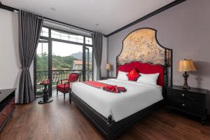 宁平Indochine Boutique Hotel Ninh Bình的一间带大床的卧室和一个阳台