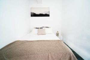 帕诺尔莫斯米科诺斯Mykonian Exclusive 3Bd Villa with Private Pool的白色的卧室,床上有毯子