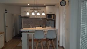 大格拉迪什泰Spa Koncept-Apartmani的厨房配有一张桌子和两张凳子