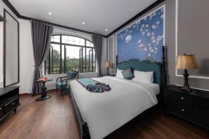 宁平Indochine Boutique Hotel Ninh Bình的一间卧室设有一张大床和一个窗户。