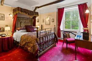 图布里奇斯双桥酒店的一间卧室配有天蓬床和红地毯