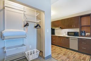 弗洛伍德TownePlace Suites by Marriott Jackson Airport/Flowood的厨房配有木制橱柜和步入式衣柜。