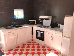 本布里奇Aule Apartment的一间厨房,配有白色家电和 ⁇ 板地板