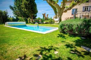 阿维尼翁Appartement d'une chambre avec piscine partagee jacuzzi et jardin clos a Avignon的一座房子的院子内的游泳池