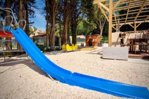 阿维尼翁Appartement d'une chambre avec piscine partagee jacuzzi et jardin clos a Avignon的公园里一个带蓝色滑梯的游乐场