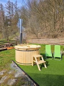 克拉斯纳利帕Alfapartmány的两把绿色椅子和一个位于庭院的热水浴池