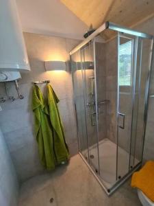 大基希海姆Ferienhaus Woodcube Großkirchheim的带淋浴和绿色毛巾的浴室