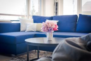 切尔诺莫雷茨Happy-U house - Modern and with stunning view的一张蓝色的沙发,桌子上放着花瓶