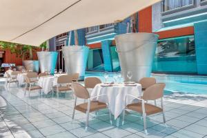 约翰内斯堡非洲梅尔罗斯普赖德阿彻傲途格精选酒店的一间带桌椅的餐厅和一个游泳池