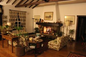 彼得罗波利斯Casa do Fachoalto的客厅设有壁炉、桌子和椅子