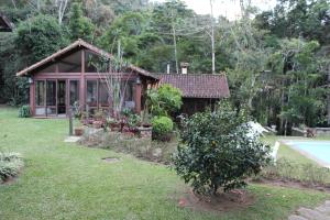 彼得罗波利斯Casa do Fachoalto的一座带花园和游泳池的小房子