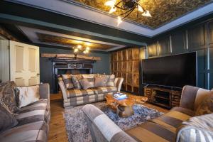 萨弗伦沃尔登Contractors Deluxe Essex Short Stay House的客厅配有两张沙发和一台电视