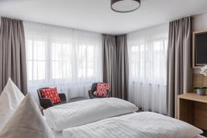 Gasthof Zum Roten Haus的一间卧室配有一张床、两把椅子和窗户