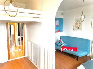 赫尔辛基Small home in Kamppi的客厅配有蓝色的沙发和高架床