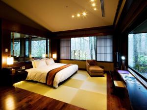 藏王竹泉荘 Chikusenso Onsen的一间卧室配有一张床、一把椅子和窗户。