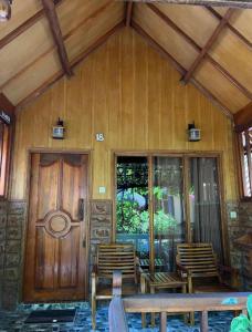 吉利阿尔Sunny Rose Bungalows Gili Air的木屋配有椅子和木门