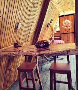 布加Glamping y Cabañas Alpina的木墙客房的木桌和凳子