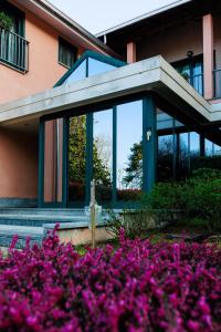 奥莱焦Hotel Villa Delle Rose - Malpensa的一座在前面布满紫色花的建筑