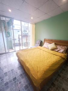 大叻DALAT INN PEACEFUL的一间卧室配有一张黄色床罩的床