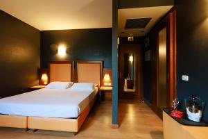 奥莱焦Hotel Villa Delle Rose - Malpensa的一间卧室配有一张大床和两张带台灯的桌子。