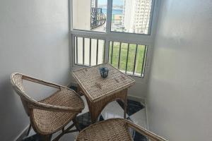 丹吉尔Beautiful Sea View Apartment in Tangier的一个带两扇窗户的房间,配有一张桌子和椅子