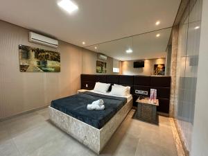 贝洛奥里藏特Motel Orion - Belo Horizonte的一间卧室配有一张大床和镜子